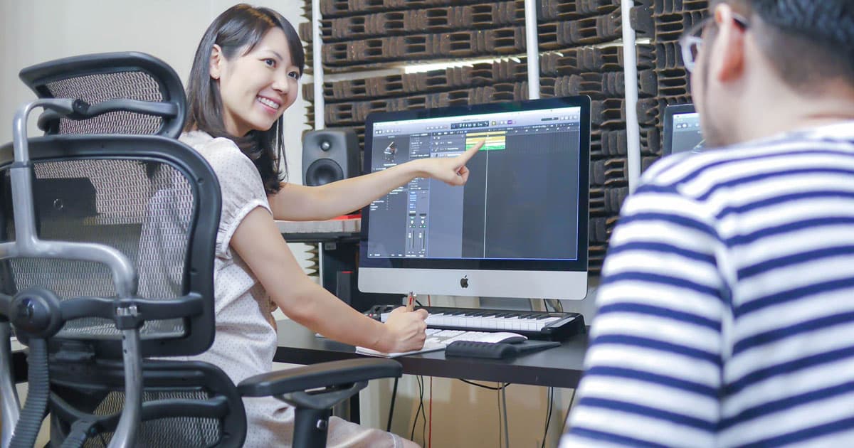 講師がマンツーマンで DAW 画面を見ながら指導するレッスン風景